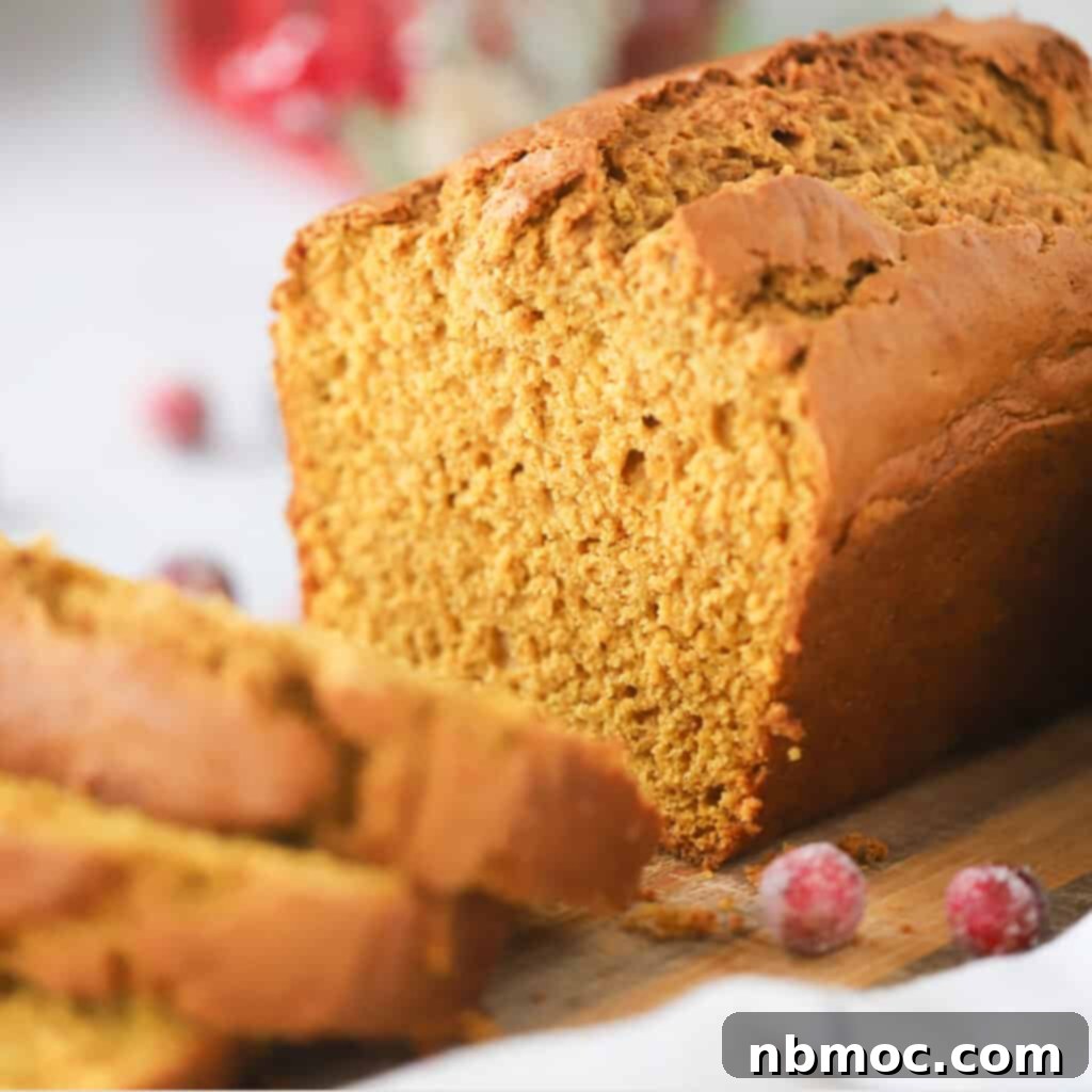 Autumn Spice Pumpkin Loaf 4 A loaf of this old-fashioned pumpkin bread recipe on a cutting board, perfectly baked.