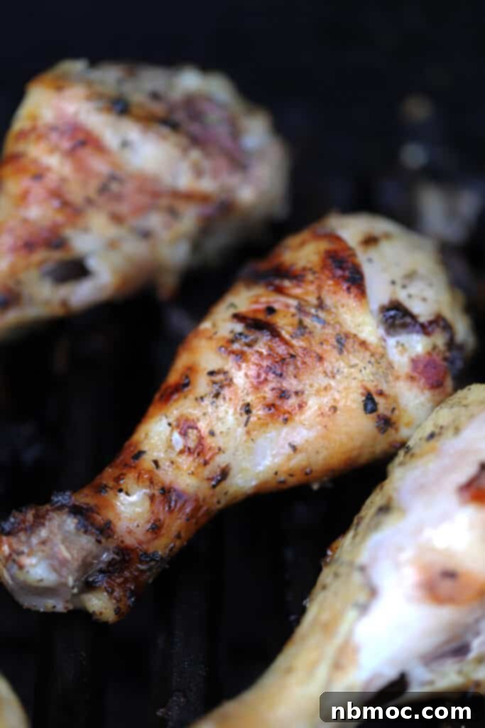 Chicken legs on a grill with golden brown char marks.