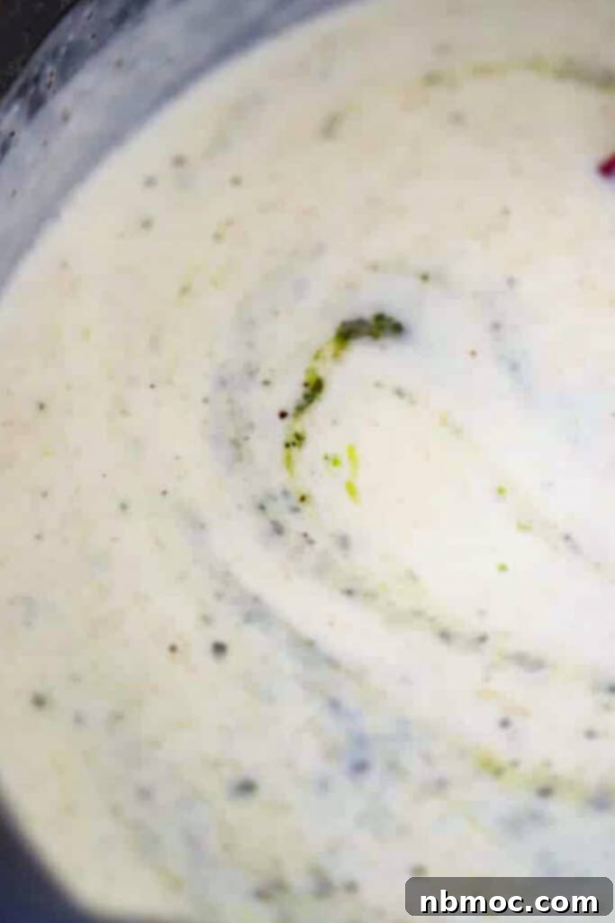 Creamy alfredo and pesto sauce in a small bowl.