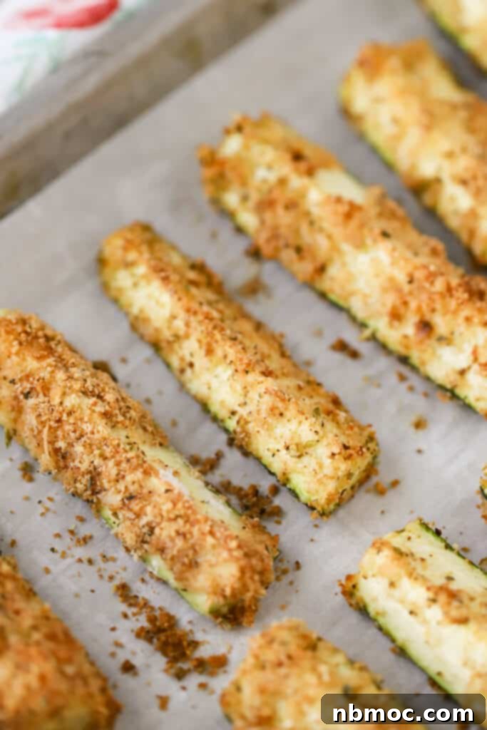 Crispy Zucchini Fries 2 A sheet tray covered with parchment paper with panko crusted baked zucchini fries, golden brown and perfectly crispy.