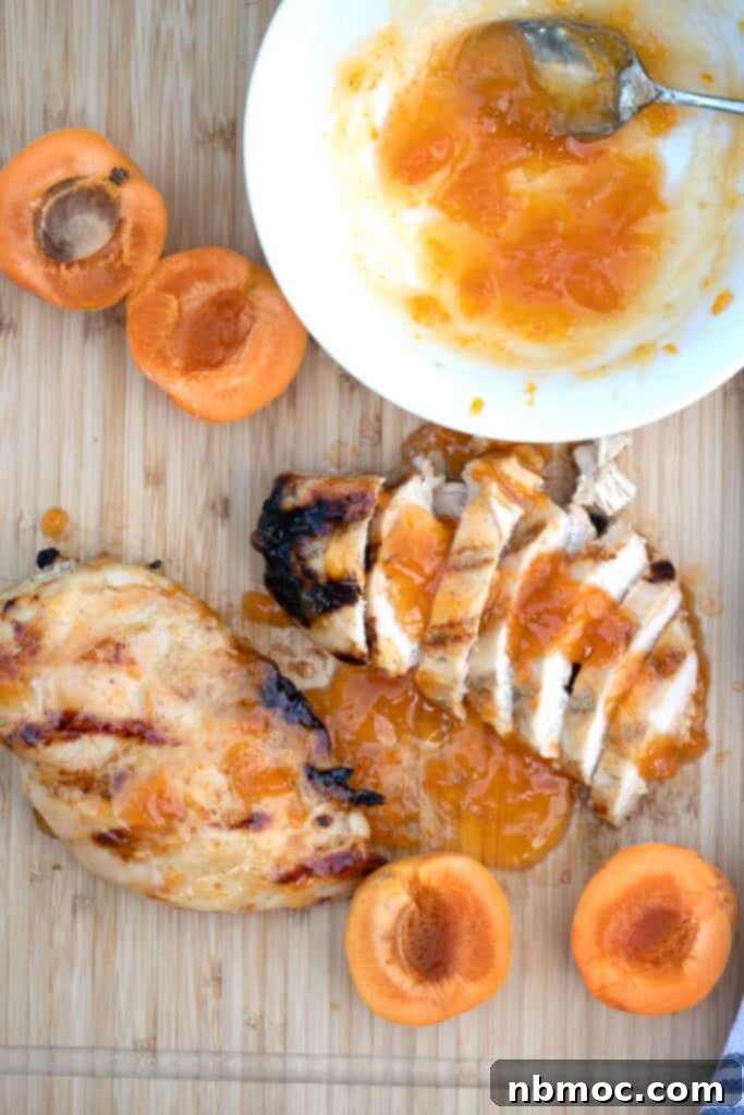 apricot chicken glaze with chicken breast on a wood cutting board with fresh apricots, chicken with apricot jam, apricot chicken breast, traditional apricot chicken recipe.