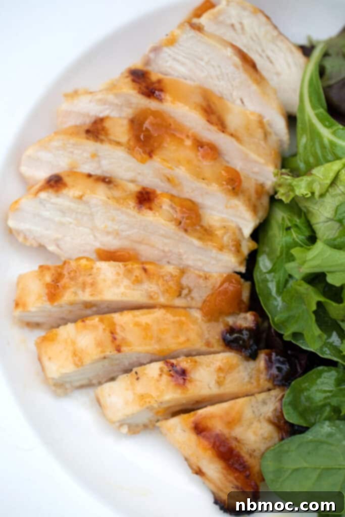 Grilled Apricot Chicken on a white plate with green salad, traditional apricot chicken recipe, apricot jam chicken, apricot chicken recipes.