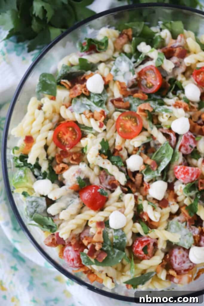 Ultimate BLT Pasta Salad 2 This BLT Pasta salad recipe in a large glass serving bowl filled with bacon, baby spinach, and tomatoes.