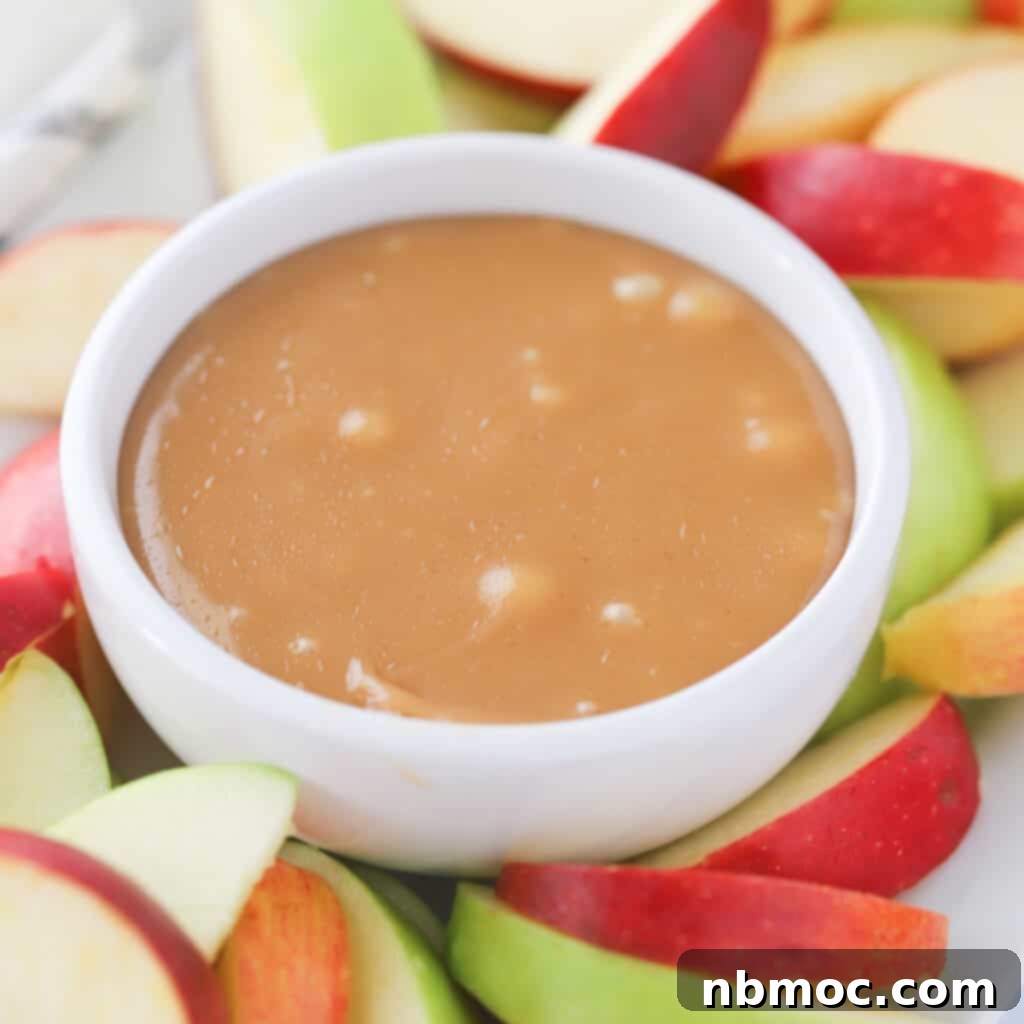 21+ Decadent Caramel Dessert Recipes 4 A white ramekin brimming with caramel dip, surrounded by perfectly sliced fresh apples.