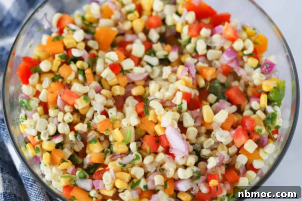 A large glass mixing bowl full of Corn Salsa.