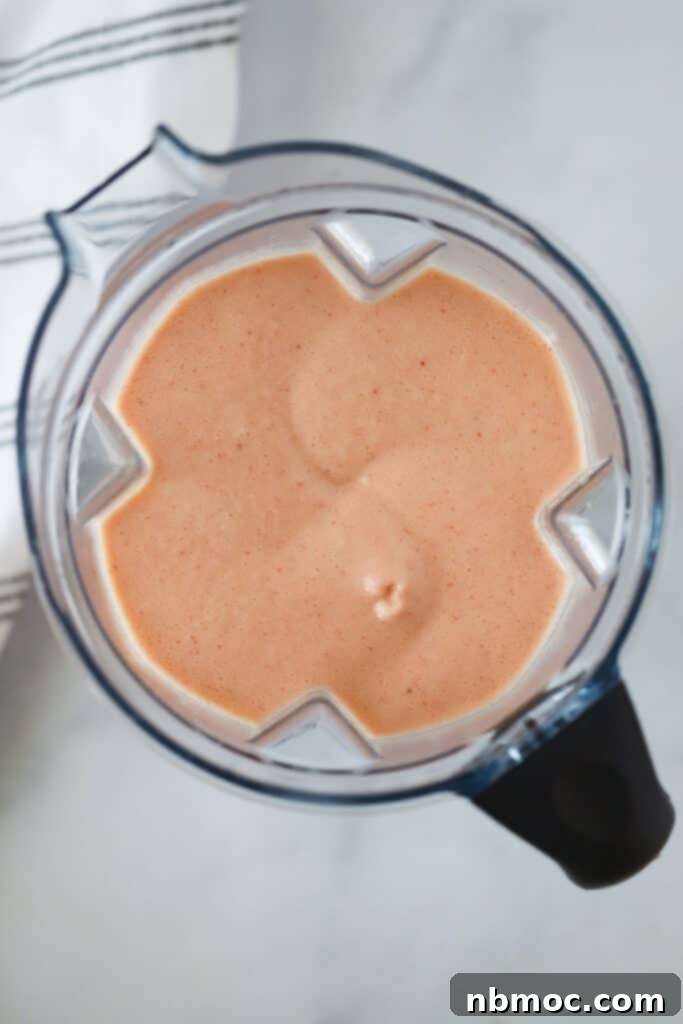 Creamy Citrus Berry Swirl 3 A picture from the top of the blender showing a strawberry orange juice frozen drink inside.