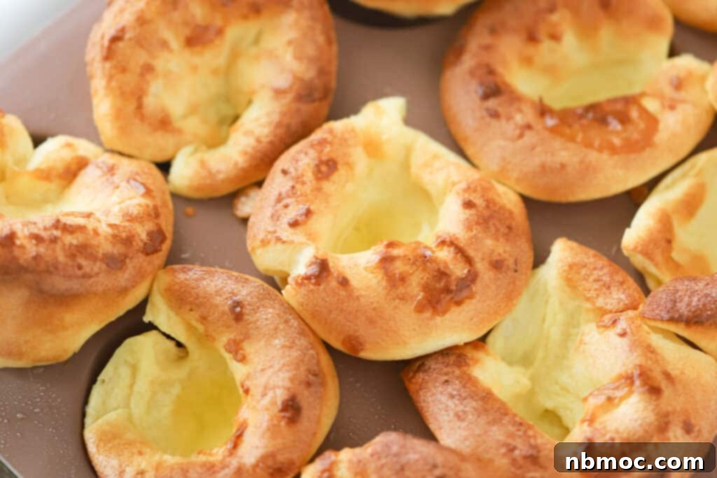 Oven-Puffed Golden Wonders 3 Freshly baked Popovers in a muffin pan, golden and perfectly puffed.