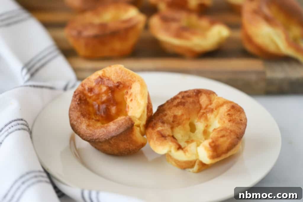 Oven-Puffed Golden Wonders 5 A white dinner plate with two perfectly baked popovers, ready to be served.
