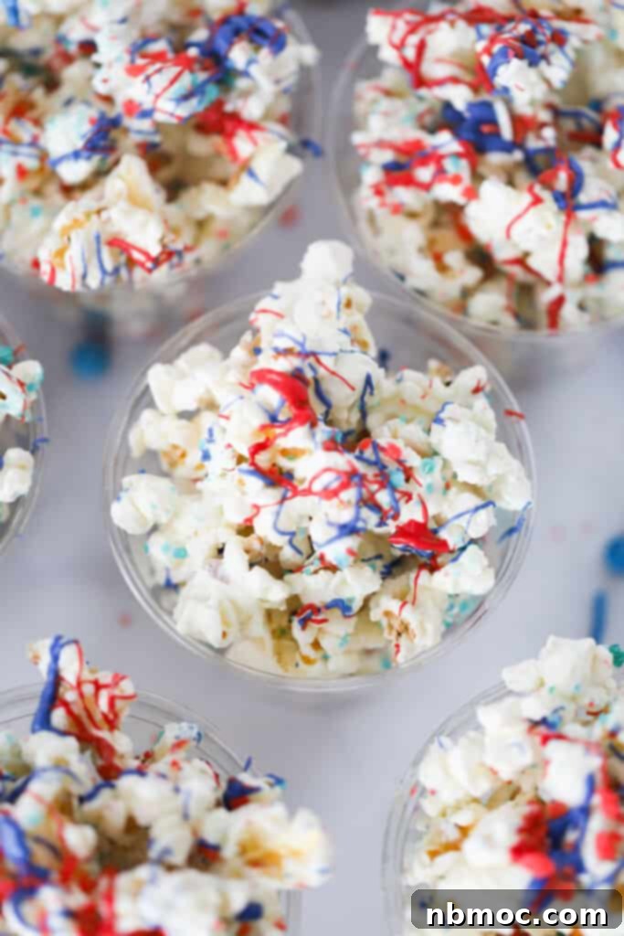 Red white and blue Popcorn inside single serving plastic cups, topped with blue and red drizzle.