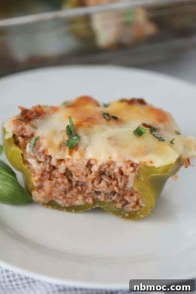 A Stuffed Pepper on a small white plate cut in half so that you can see the filling inside. best filling for stuffed peppers. 