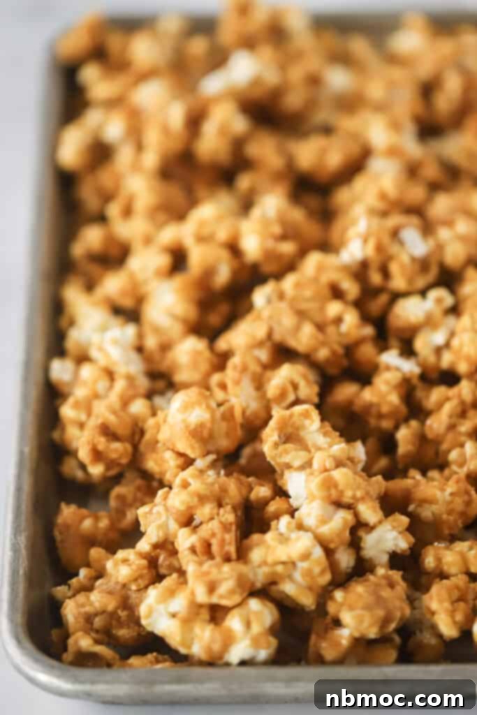 A baking sheet full of Cracker Jacks Popcorn, full of salty sweet cracker jack peanuts.