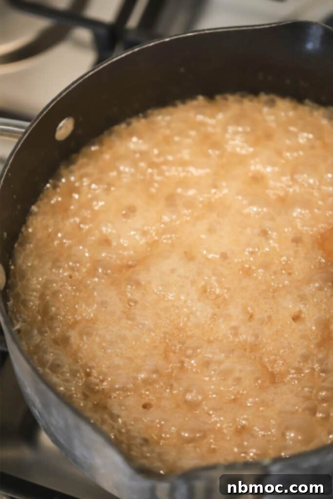 A large pot full of caramel cooking to make this homemade cracker jack recipe. 