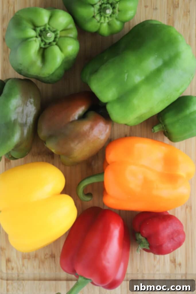 A vibrant assortment of different colored bell peppers arranged on a cutting board, ready for preparation.
