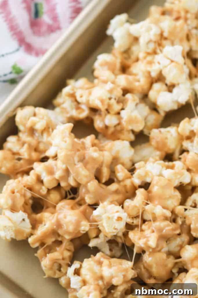 A baking sheet with a layer of Peanut Butter Popcorn cooling. popcorn peanut butter. peanutbutter popcorn, popcorn dessert, popcorn 1 cup.