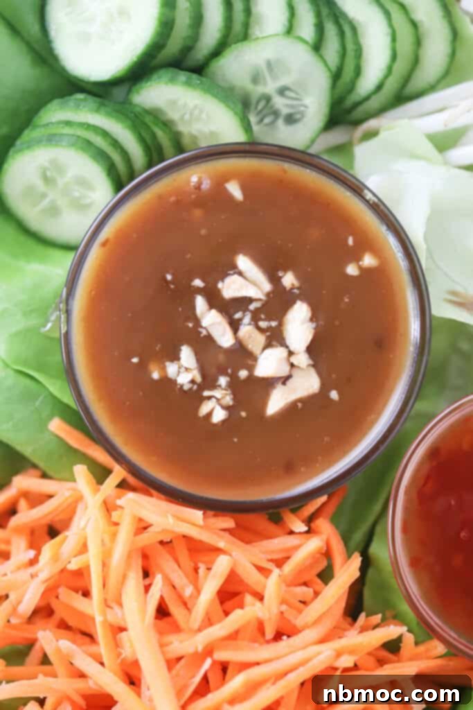Creamy Peanut Dipping Sauce 2 A bed of lettuce with julienned carrots, sliced cucumbers, and a ramekin full of pad thai peanut sauce, ready for serving.