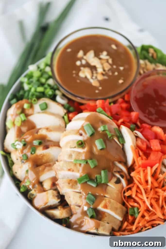 A serving bowl with Thai Chicken Chopped Salad and a ramekin of peanut sauce. Thai salad recipe, thai chicken salad, thai chopped salad.