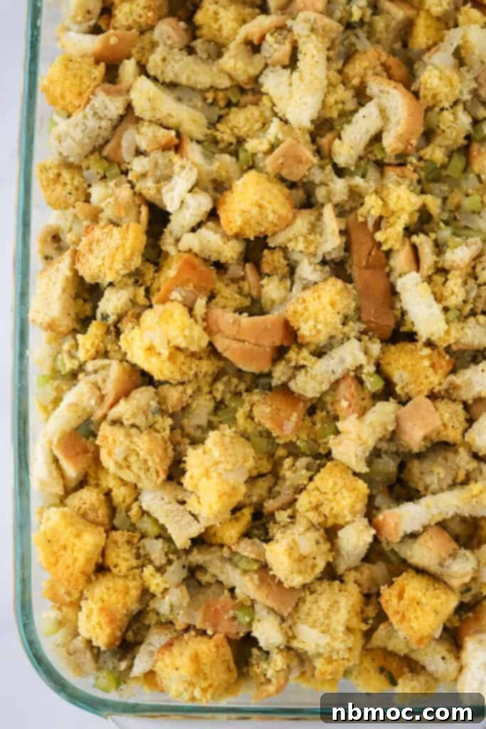 A large baking pan filled with the best Cornbread Stuffing recipe, perfectly assembled and ready to be transferred into a preheated oven.