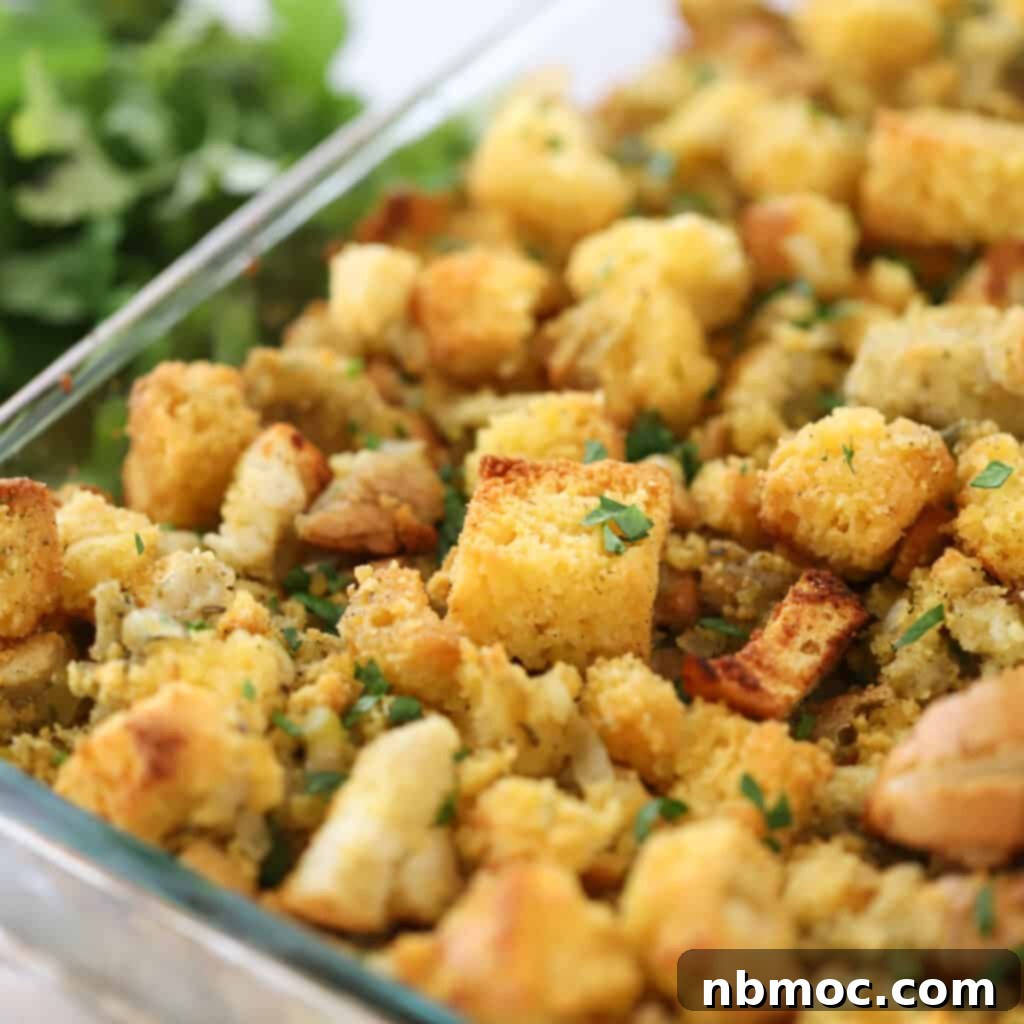 A stunning close-up of the finished cornbread stuffing recipe, served in a elegant glass baking dish, showcasing its golden crust and moist interior, the best cornbread stuffing for any occasion.