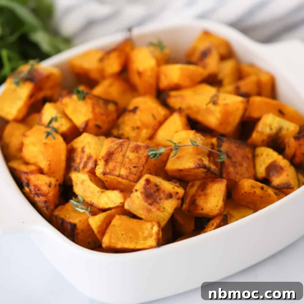 Golden Roasted Squash 3 A large white serving dish showcasing oven-roasted squash, elegantly topped with fresh green herbs.