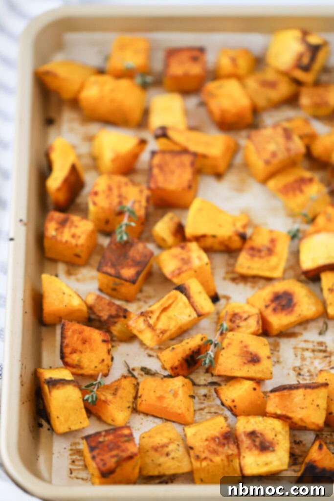 Golden Roasted Squash 4 A sheet pan lined with parchment paper and covered with perfectly roasted squash cubes, glistening and slightly browned.