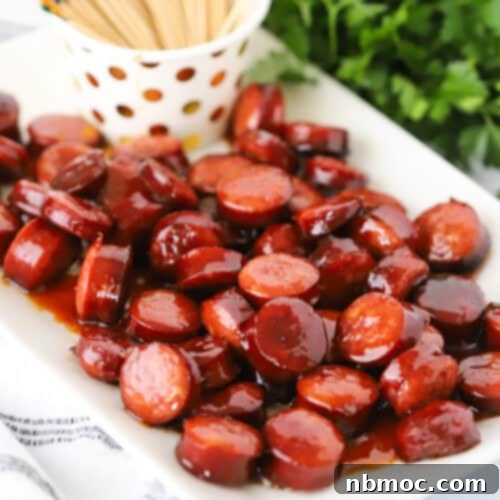 candied kielbasa on a white serving platter with fancy toothpicks