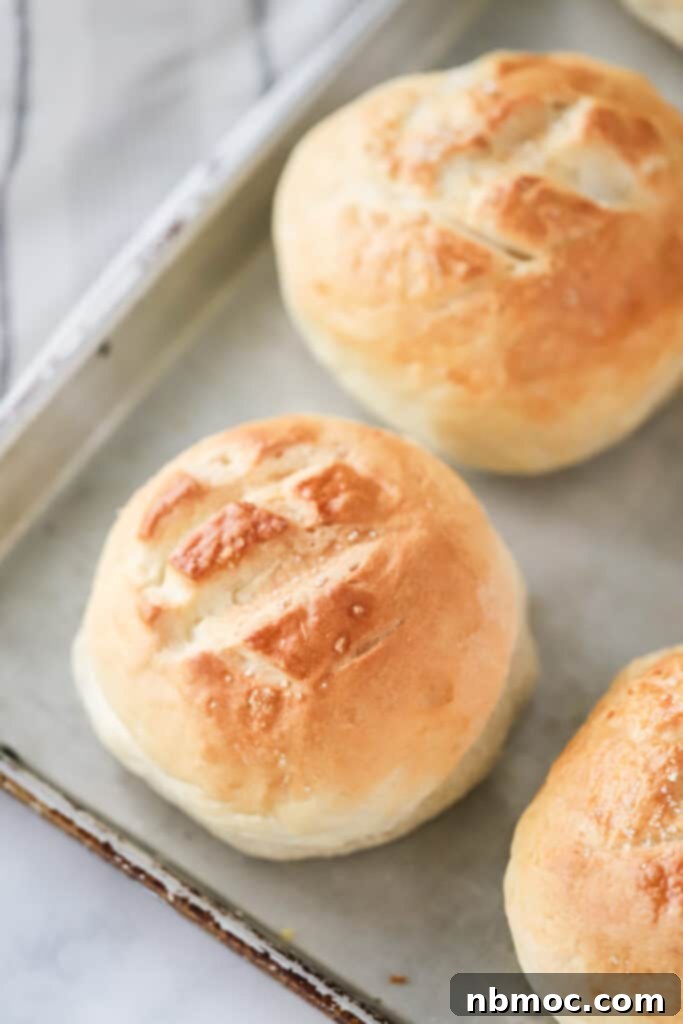 Crusty Creations 2 Freshly baked golden-brown bread bowls resting on a baking sheet, ready to be filled with delicious soup. Perfect for soup season and entertaining guests.