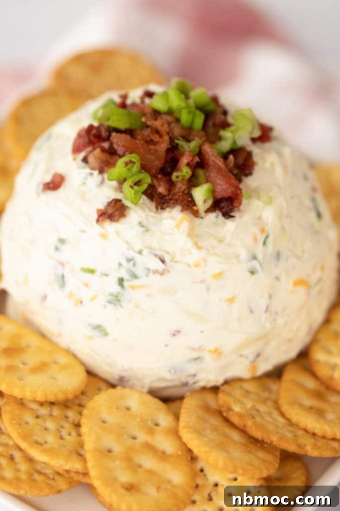 A close-up shot of a creamy cheese ball recipe, generously mixed with cream cheese, savory bacon, and zesty ranch seasoning, ready to be served.