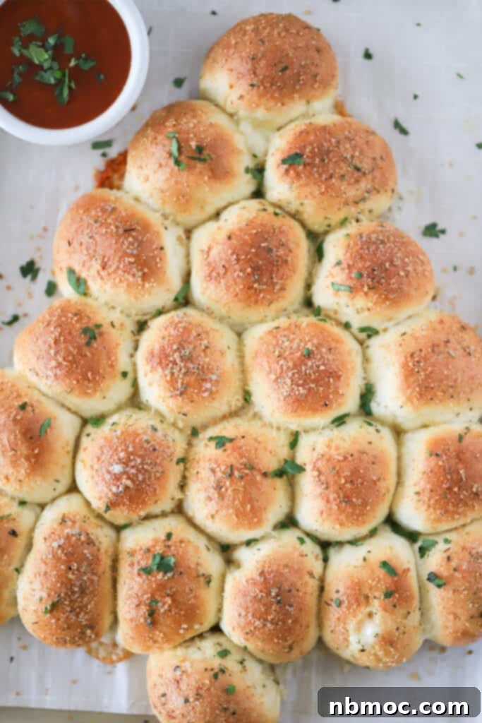 Garlic Butter Christmas Tree Rolls 2 A baking sheet with golden-brown Garlic Pull-Apart Rolls baked in a beautiful Christmas tree shape, ready to be served. These homemade garlic rolls are a delicious and easy holiday recipe.