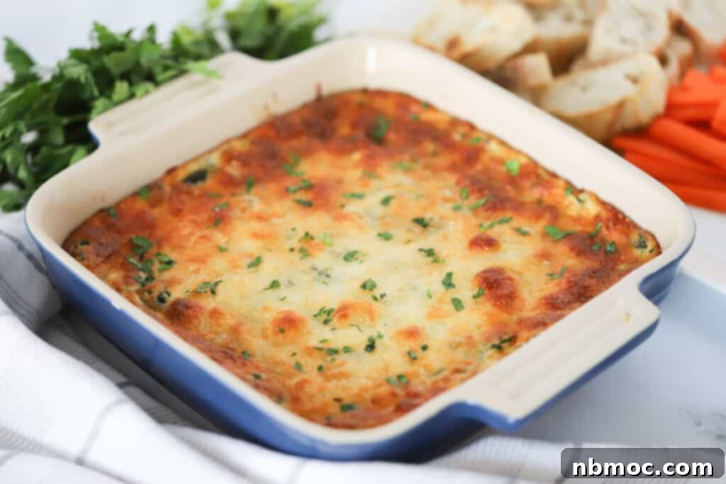 Creamy Spinach Delight 2 A square baking dish full of baked Warm Spinach Dip, golden brown and bubbly, ready to be served.