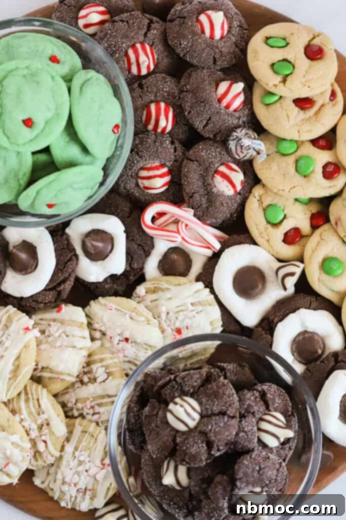 A large wooden board with different types of Christmas cookies arranged to make a cookie board.