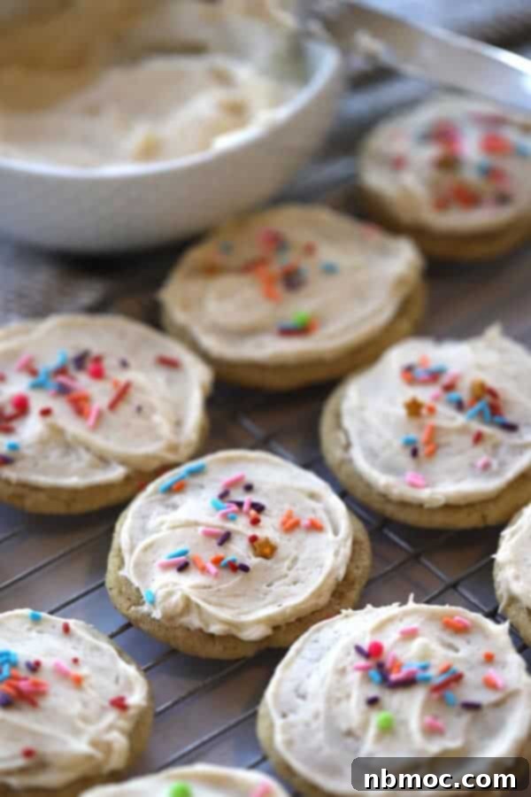 egg nog christmas cookies on a wire cooling rack with egg nog frosting and sprinkles.