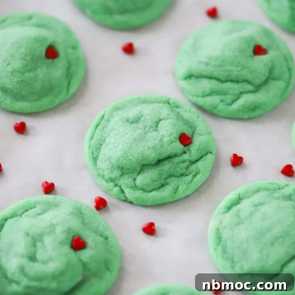 green Grinch cookies with little red candy hearts, perfect cookie platter presentation.