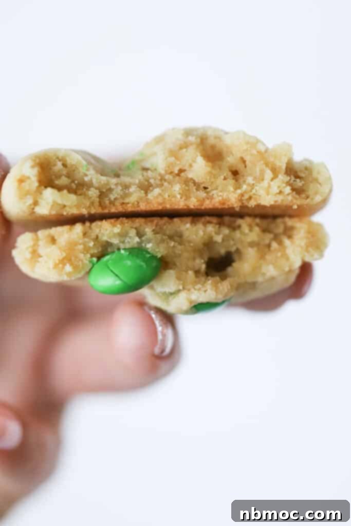 A festive stack of homemade Christmas M&M cookies, vibrant with red and green candies and melted chocolate chips, perfect for holiday gatherings.