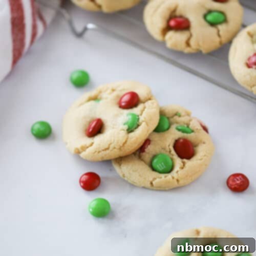 A plate of freshly baked Christmas M&M cookies, soft and chewy, with colorful red and green candies.