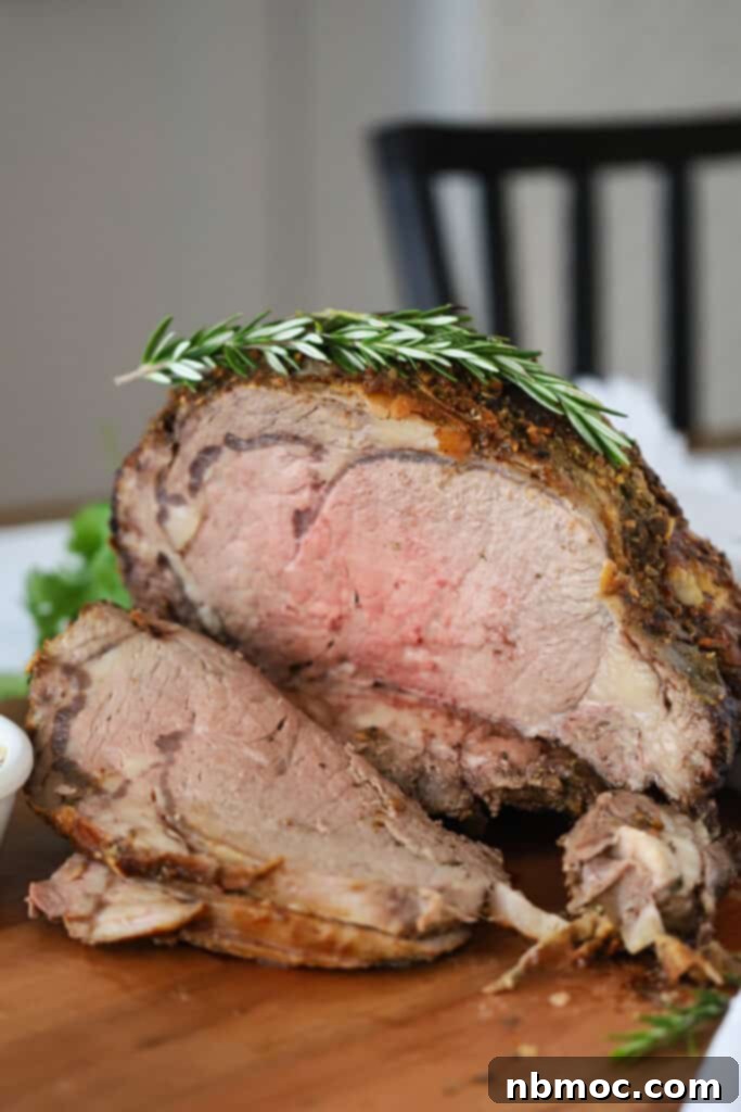 A cutting board with perfectly sliced roast beef garnished with fresh rosemary, ready to serve, highlighting ideal doneness and presentation.