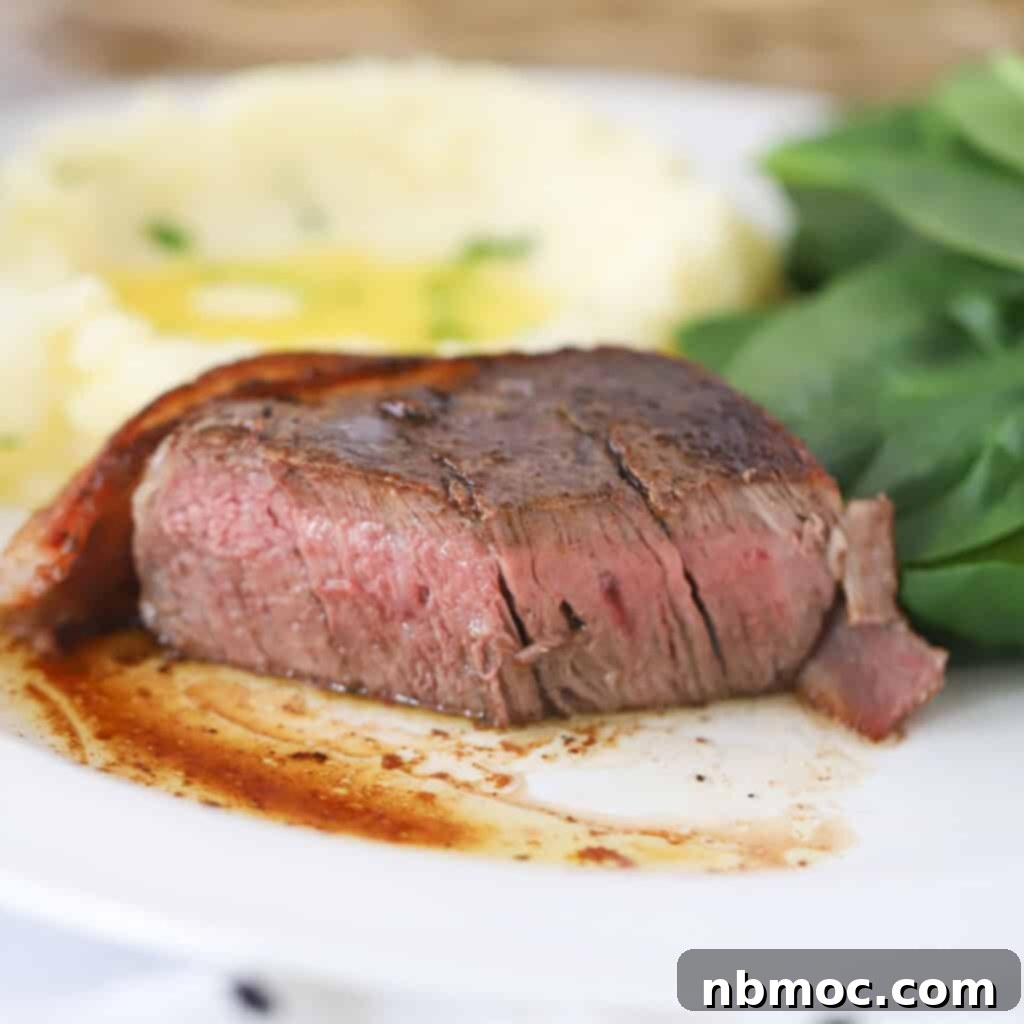 Valentines Day Dinner Inspiration 3 A perfectly cooked Bacon Wrapped Filet Mignon served on a white dinner plate with a side of creamy mashed potatoes, making for an elegant Valentine's Day meal.