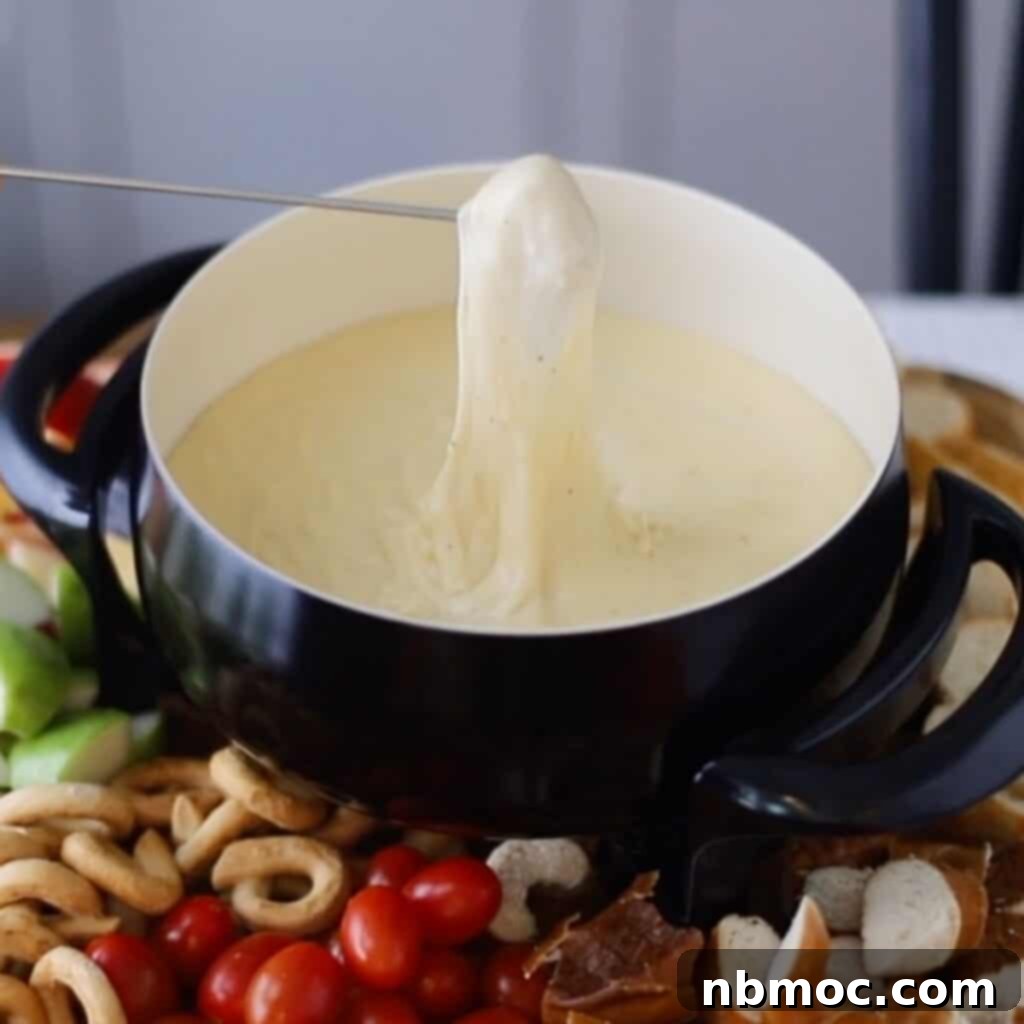 Valentines Day Dinner Inspiration 6 A bubbling pot of creamy Homemade Cheese Fondue, surrounded by dippers, offering a fun and romantic Valentine's menu idea.