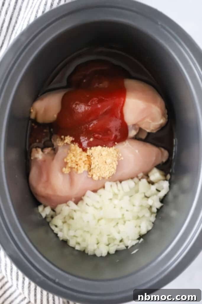 Slow Cooker Zesty Pulled Chicken Sliders 4 A slow cooker with raw chicken breasts, ketchup, onions, and garlic to make these crock pot chicken sliders. pulled chicken breast crock pot.