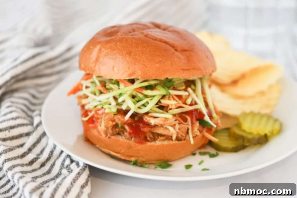 Slow Cooker Zesty Pulled Chicken Sliders 5 A dinner plate with a Tangy Crockpot Chicken Sliders, pickles, and potato chips. Hawaiian Roll Chicken Sliders, chicken sliders crock pot.