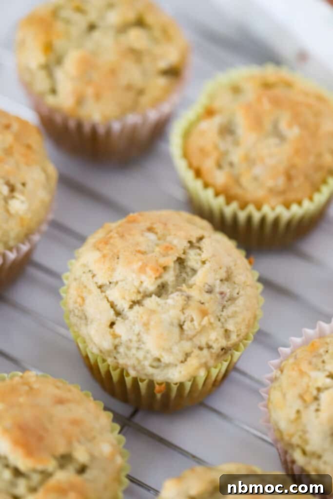 Nourishing Banana Muffins 3 Delicious banana yogurt muffins cooling on a wire rack after baking, showcasing their golden-brown tops.