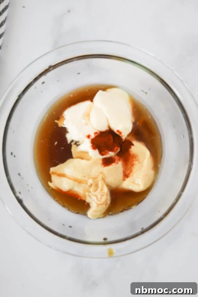 A small glass mixing bowl with ingredients to make Honey Mustard sauce. Recipe with mustard sauce, honey mustard dip recipes, recipe honey mustard dipping sauce. Honey mustard dipping recipe.