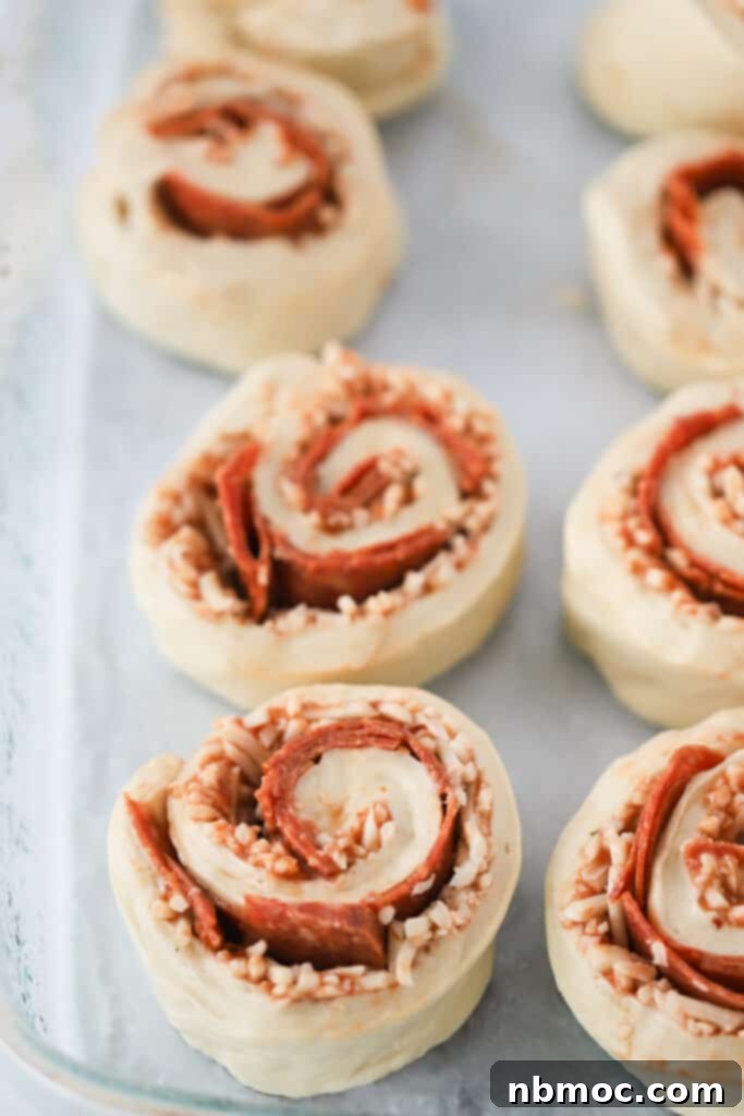Cheesy Pizza Pinwheels 6 A baking dish with pizza rolls filled with cheese and pepperoni. pizza roll up recipe, homemade pizza recipe. Pepperoni roll ups.