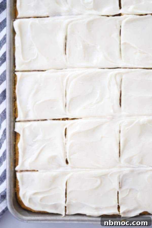 Harvest Pumpkin Spice Squares 2 Freshly baked pumpkin cream cheese bars, perfectly cut and arranged in a baking sheet, ready to be served for a delightful fall treat.