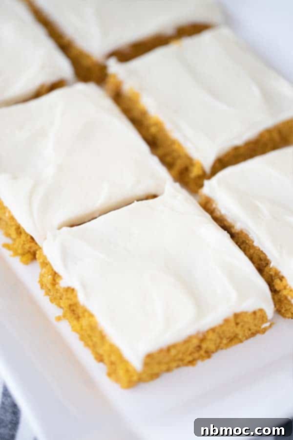 Harvest Pumpkin Spice Squares 4 A beautifully arranged serving plate of frosted pumpkin squares, garnished with a sprinkle of cinnamon, ready to be enjoyed.