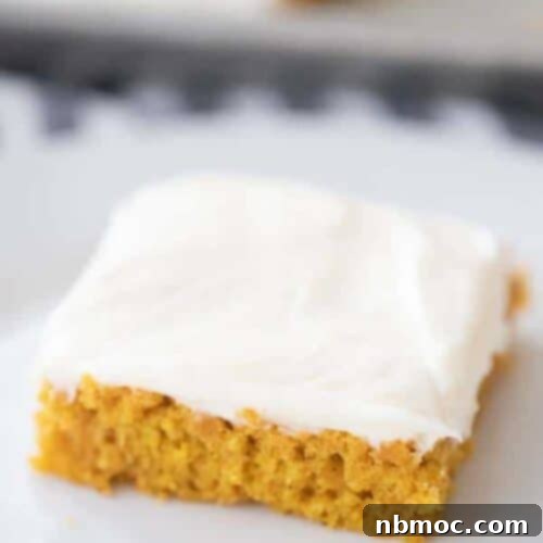 Harvest Pumpkin Spice Squares 5 A close-up of a frosted pumpkin bar, showcasing the moist cake and thick, creamy frosting.