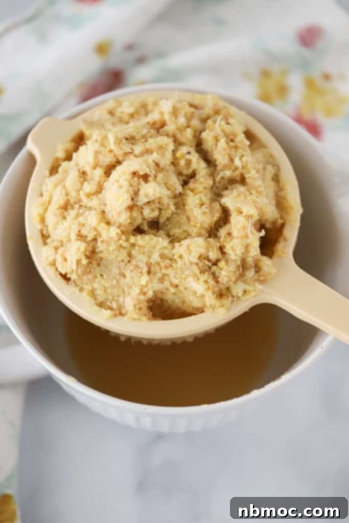 The pulp from making Ginger Honey Lemon Tea being strained over a bowl.