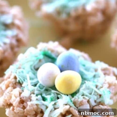 Rice Krispies treat decorated to look like a birds nest, with three chocolate eggs on top.