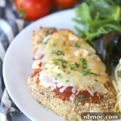 oven baked chicken parmesan on a plate with salad