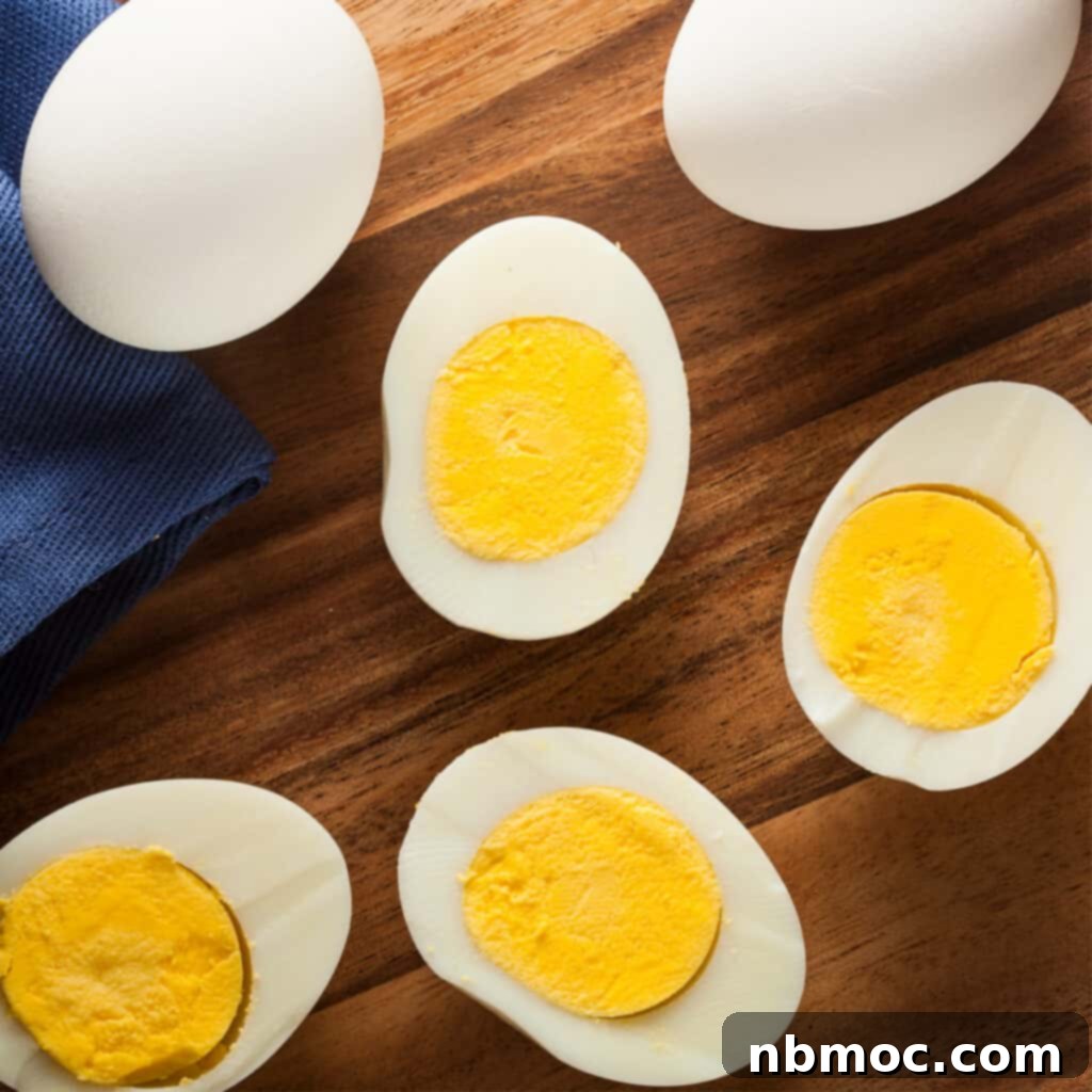 Perfectly cooked hard-boiled eggs on a cutting board, ready for use. These baking soda hard boiled eggs are ideal for any dish.