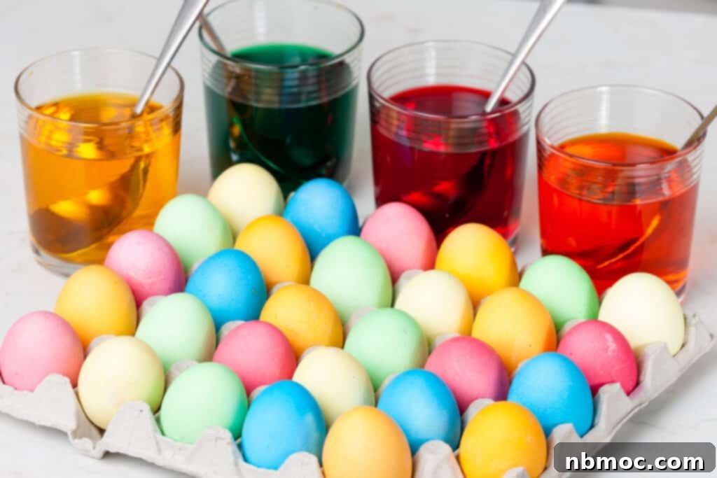 Crafting Colorful Easter Eggs 6 A full carton of colorful Easter Eggs with cups of dye behind; dyed Easter eggs; how to dye Easter eggs with food coloring. Dyeing Easter eggs, food coloring to dye easter eggs, dyeing eggs, easter eggs coloring.